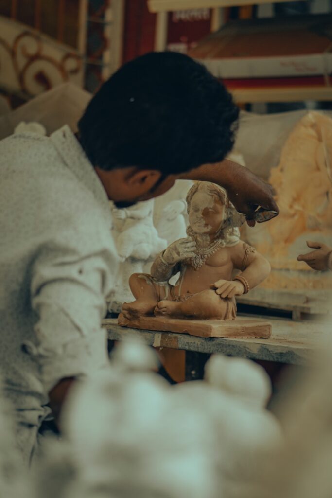 A woman standing over a table with a doll on it